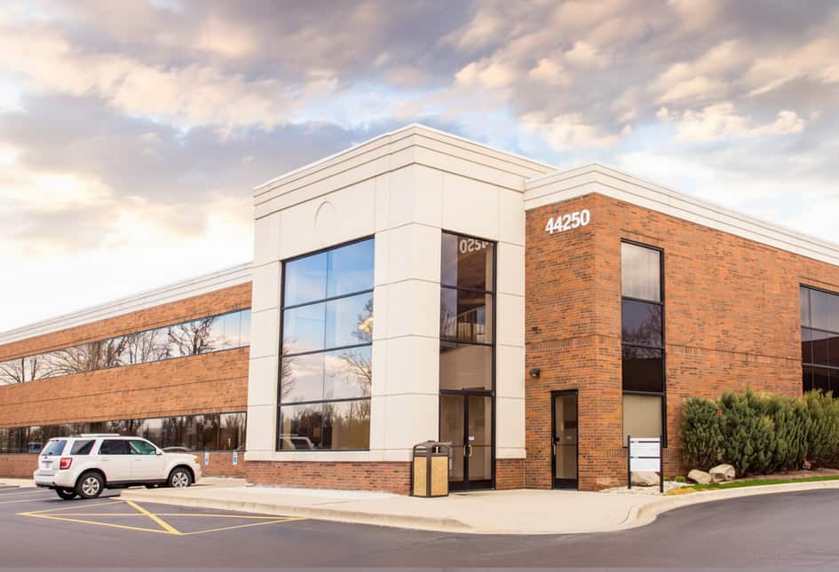 Modern medical building of Nerve & Disc Institute with parking lot.