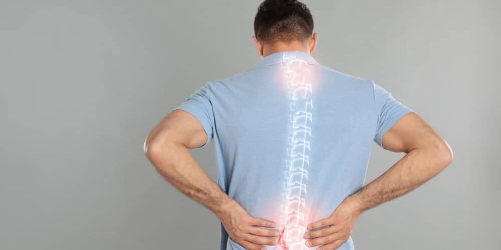 Man experiencing lower back pain with highlighted spine illustration for lumbar stenosis.